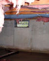 Colorado crawl space with vents, showing mold, rot, and fiberglass insulation dripping off the ceiling.